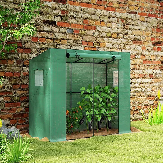 Outsunny Gewächshaus - 200 x 76 cm, Material Seitenwand: Kunststoff, 0,3 mm, Dunkelgrün - Grünes tragbares Gewächshaus mit Pflanzen, im Garten vor einer Ziegelwand.