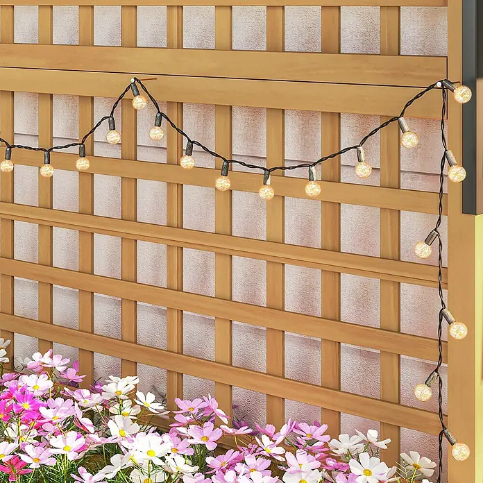 Outsunny Hochbeet - 90 x 45 x 183 cm, Holz, Gelb - Hölzernes Gartenspalier mit warmen Lichterketten und darunter leuchtenden rosa-weißen Kosmeen.