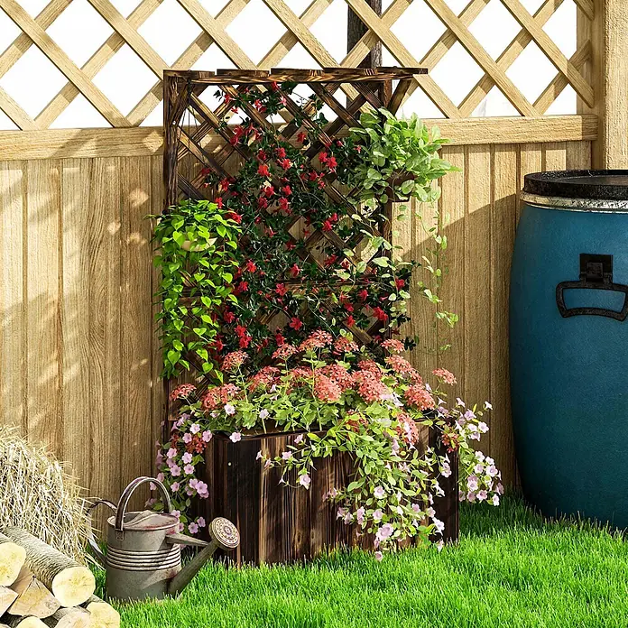 Furnicato Hochbeet - 64 x 33 x 122 cm, Holz, Verkohlt - Dunkelbrauner Holzpflanzkasten mit integriertem Rankgitter, der rote und grüne Kletterpflanzen trägt und mit rosa Blumen gefüllt ist, in einem Garten.