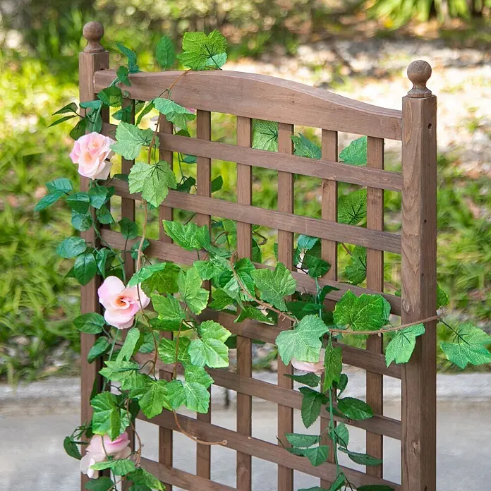 Outsunny Hochbeet - Holz, Dunkelbraun - Dunkelbraunes Holzgitter für den Garten mit künstlichen grünen Ranken und zarten rosa Rosen verziert.