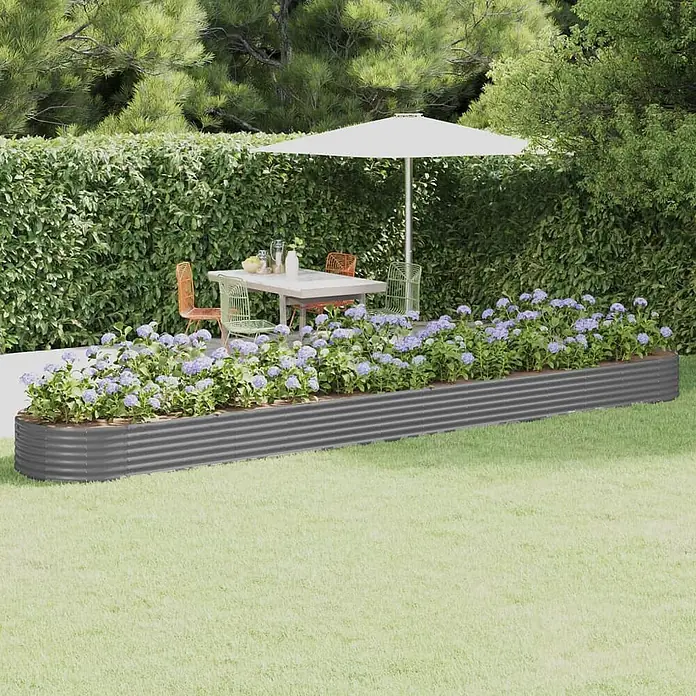 Furnicato Hochbeet - 544 x 100 x 36 cm, Stahl, Grau - Dunkelgraues Hochbeet aus Wellblech mit lila Blumen in einer grünen Gartenumgebung.