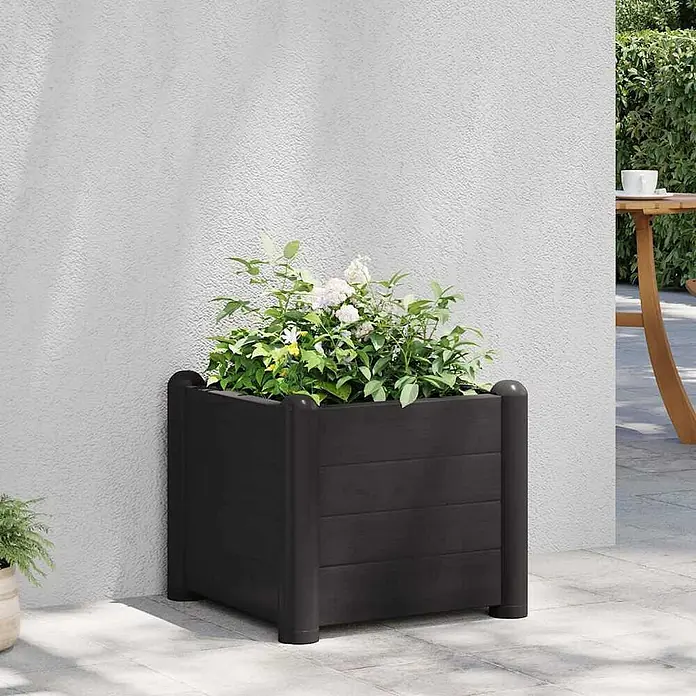 Furnicato Hochbeet - 43 x 43 x 35 cm, Kunststoff, Anthrazit - Dunkelgrauer quadratischer Pflanzkasten mit grünen Pflanzen und weißen Blüten auf einer Terrasse.