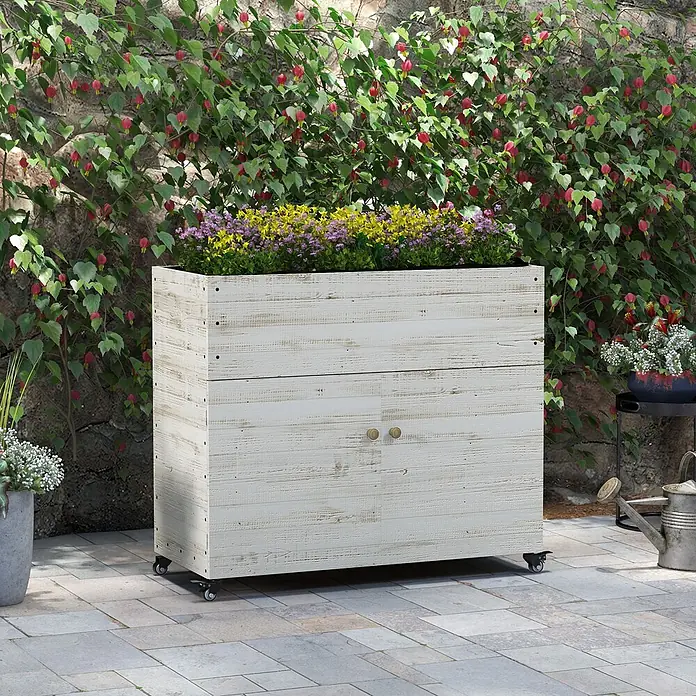 Furnicato Hochbeet - 110 x 50 x 95 cm, Holz, Weiß - Pflanzkasten aus weißem Altholz auf Rollen mit Unterschrank, bepflanzt mit Blumen, auf einer Terrasse.