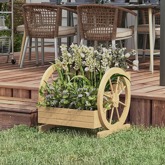 Outsunny Hochbeet - 62 x 61 x 57 cm, Holz, Naturholz - Heller hölzerner Wagenrad-Pflanzkübel mit weißen und grünen Pflanzen, auf Gras neben einer Terrasse.