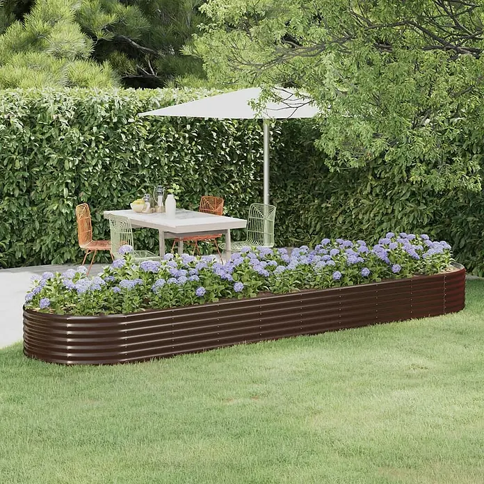 Furnicato Hochbeet - 396 x 100 x 36 cm, Stahl, Braun - Ein langes, braunes Hochbeet aus Wellblech, gefüllt mit lila Blumen, auf einem Rasen neben einer Terrasse mit Gartenmöbeln.