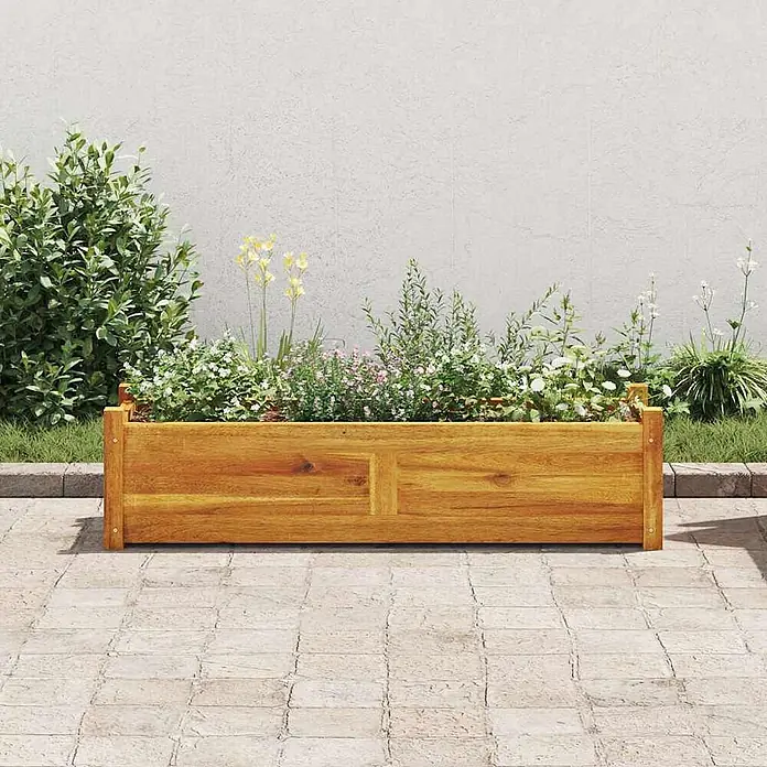Furnicato Hochbeet Akazienholz geölt - 100 x 30 x 25 cm, Holz, Braun - Langes braunes Holz-Pflanzgefäß gefüllt mit bunten Pflanzen und Blumen auf einem gepflasterten Patio.