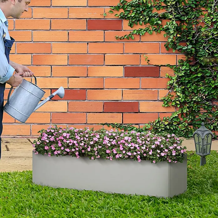 Outsunny Pflanzkübel eckig - Außenmaß (L x B x H): 91 x 22 x 22 cm, Stahl, Grau - Grauer, rechteckiger Pflanzkübel mit rosa Blumen, in einem Garten bewässert.