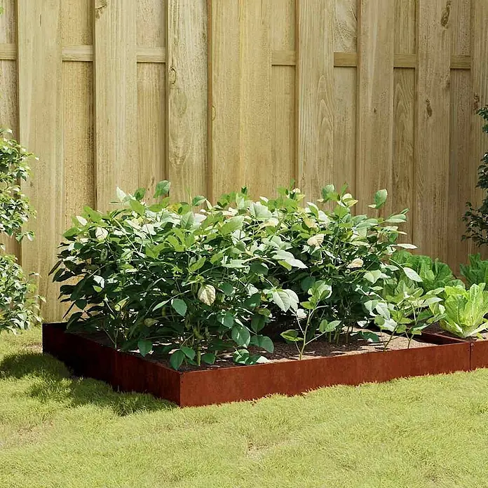 Furnicato Hochbeet - 100 x 100 x 26 cm, Stahl, Witterungsbeständiger Stahl/Braun - Rostbraune Metallbeeteinfassung für ein Hochbeet mit Pflanzen im Garten vor einem Holzzaun.