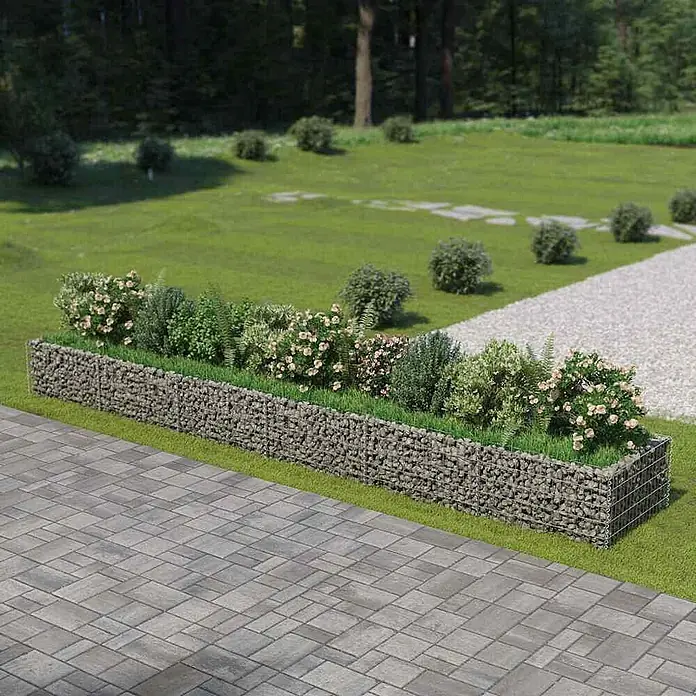 Furnicato Hochbeet - 90 x 540 x 50 cm, Stahl, Silber - Langes Gabionen-Pflanzgefäß mit grauen Steinen, verschiedenen Grünpflanzen und blühenden Sträuchern im Garten.
