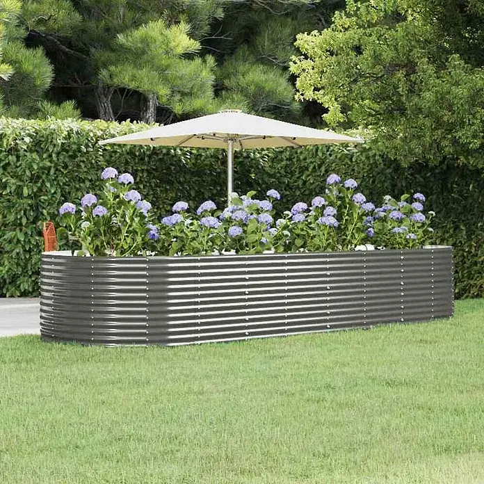 Furnicato Hochbeet - 367 x 367 x 68 cm, Stahl, Grau - Langes, dunkelgraues Hochbeet aus Wellblech in einem Garten, gefüllt mit lila Blumen.