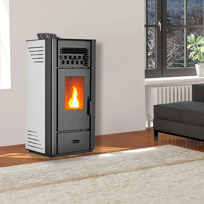 Sannover Pelletofen Anita 11,6 kW Sannover Weiß - 10 kW, Raumheizvermögen: 240 m³, 2,2 kg/h, Farbe Verkleidung: Weiß - Schwarz-weißer Pelletofen mit sichtbarer Flamme in einem Wohnzimmer am Fenster, der Wärme spendet.