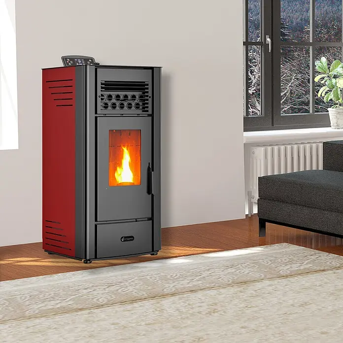 Sannover Pelletofen - 10 kW, Raumheizvermögen: 240 m³, 2,2 kg/h, Farbe Verkleidung: Bordeauxrot - Roter und schwarzer Pelletofen mit sichtbarer Flamme, heizt einen Raum.