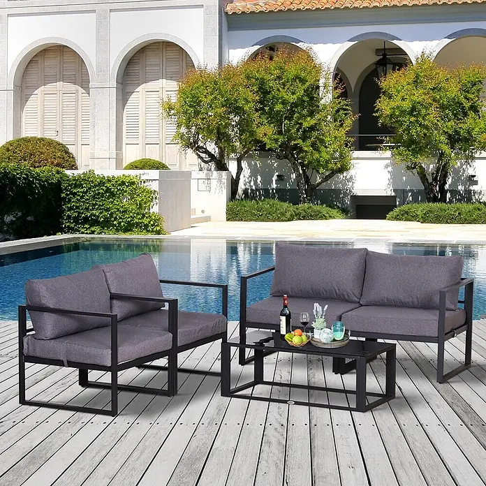 Outsunny Loungemöbel-Set 4-tlg. mit Tisch - 4 -tlg., Aluminium, Polyester, mit Tischplatte aus gehärtetem Glas, Grau - Ein Outdoor-Terrassenmöbelset mit schwarzen Metallrahmen und dunkelgrauen Kissen, bestehend aus Zweisitzer-Sofa, Sessel und Couchtisch, auf Holzterrasse am Pool.