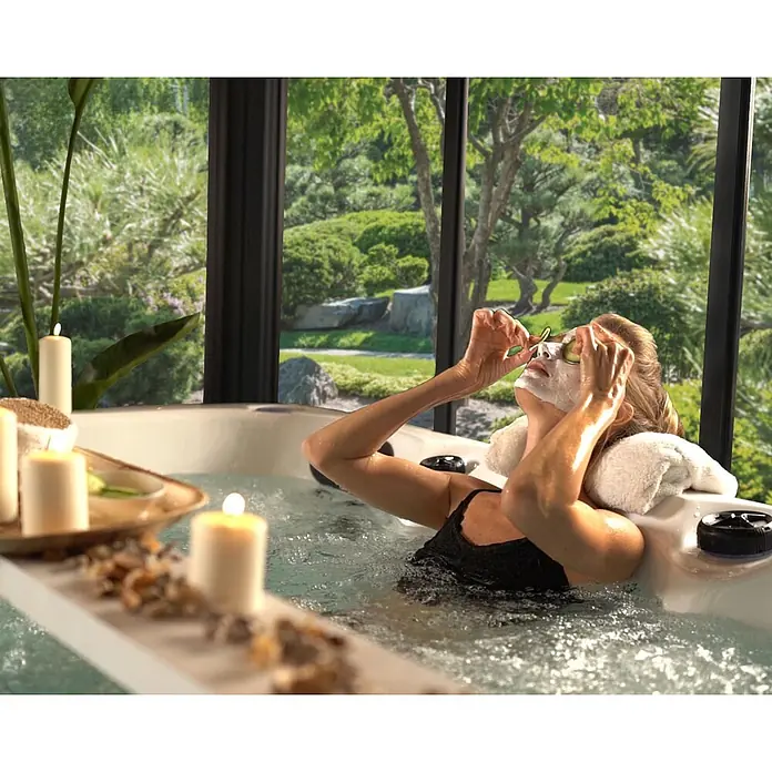 Palram – Canopia Pérgola de jardín cerrado Ledro - An x Pr: 360 x 360 cm, Color del armazón: Antracita, Aluminio - Mujer relajándose en jacuzzi burbujeante con mascarilla facial, rodajas de pepino en los ojos y velas, con vistas a un jardín.