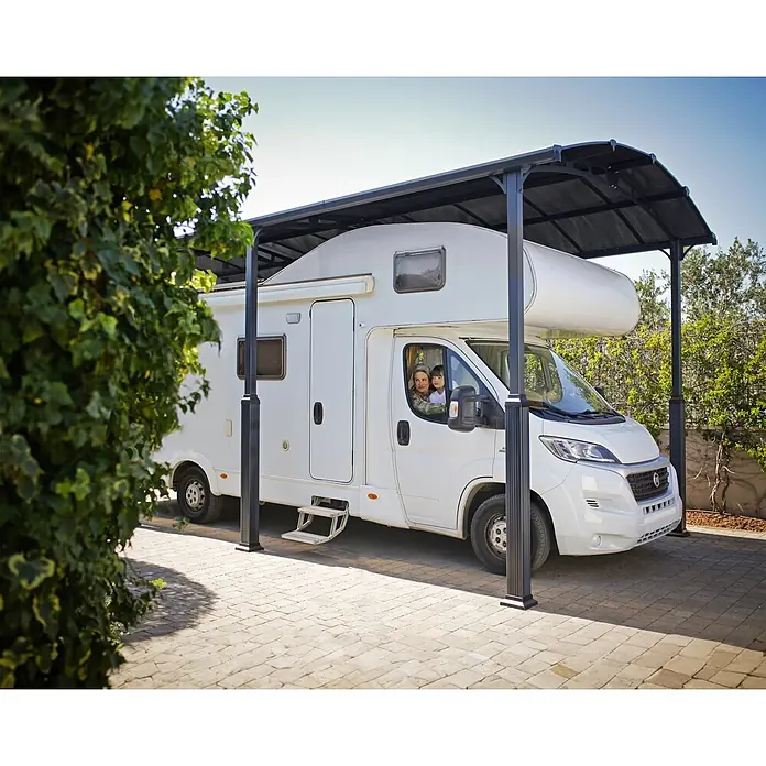 Palram – Canopia Carport Alpine - Medidas ext. (An x Pr): 3,59 x 8,63 m, Carport individual, Antracita - Marquesina metálica gris oscuro cubriendo una autocaravana blanca con gente dentro.