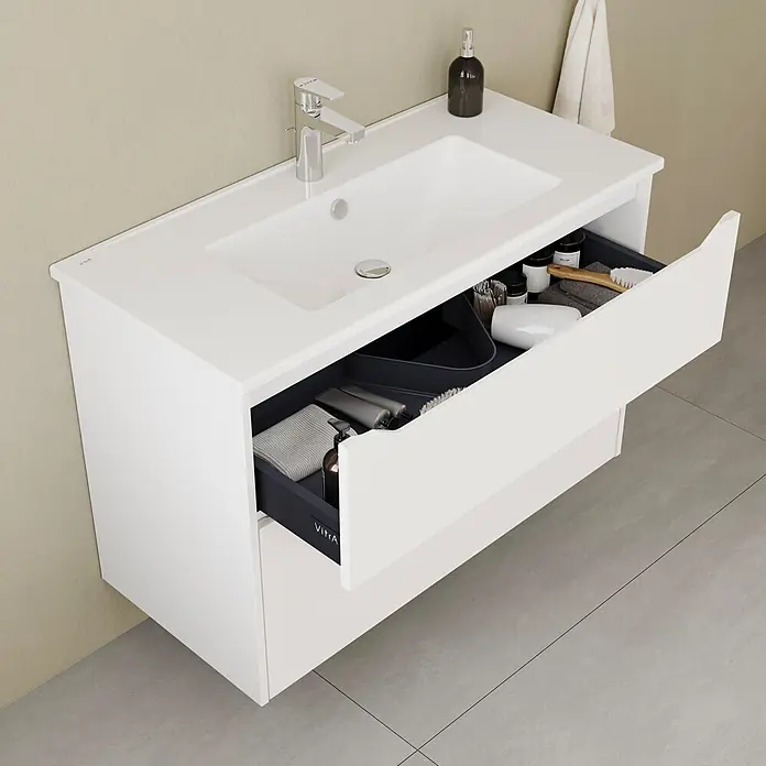 VitrA Integra Square Badmöbel-Set - Gesamtbreite Badmöbel: 100 cm, Weiß, Matt - Weißer Badunterschrank mit integriertem Waschbecken und Chromarmatur. Eine offene Schublade zeigt dunkelgraue Organizer und Toilettenartikel.