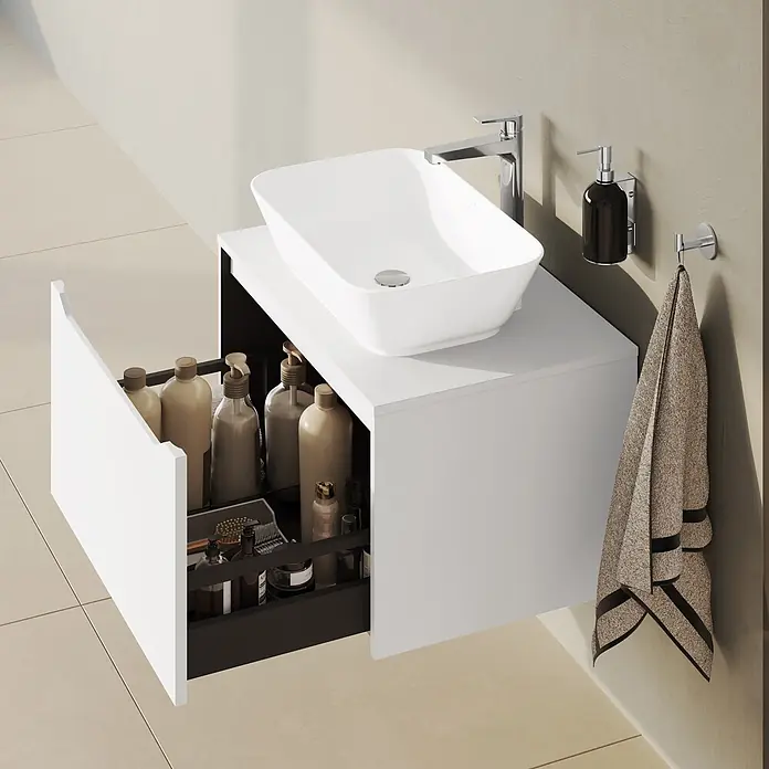 VitrA Integra Square Waschtischunterschrank Integra Square - B x T x H: 80 x 52 x 42 cm, Weiß - Weißer schwebender Badezimmerschrank mit rechteckigem Waschbecken, Chromarmatur und geöffneter Schublade mit Pflegeprodukten. Ein beiges Handtuch hängt an der Wand.