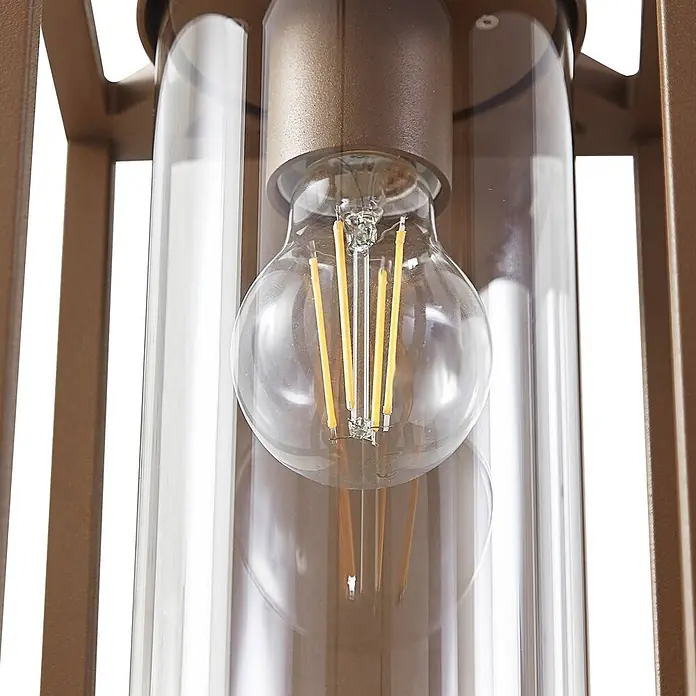 Lucande Wandleuchte aussen in braun, Aussenlampe Wand -  - Nahaufnahme einer LED-Filamentlampe in einem Klarglaszylinder, gehalten von einer bronzefarbenen Metallhalterung.