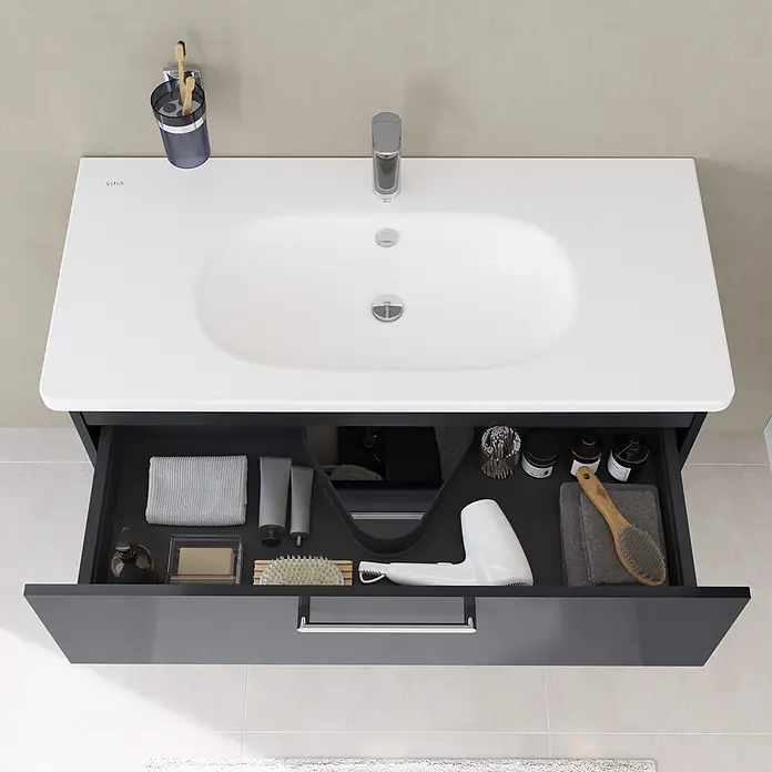 VitrA Badmöbel-Set Root Flat - B x T x H: 80 x 45 x 65 cm, Anthrazit, Hochglänzend - Dunkelgrauer Badschrank mit weißem Waschbecken und offener Schublade, die geordnete Toilettenartikel und einen Föhn zeigt.