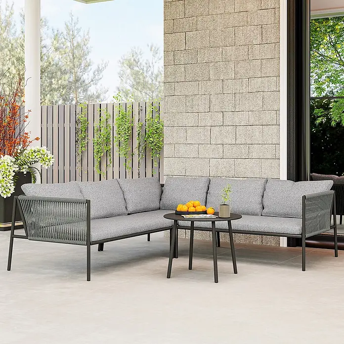 Outsunny Gartenstuhl-Set Polyrattan Lounge-Set -  - Graue L-förmige Outdoor-Sofagarnitur mit Seildetails und einem runden Couchtisch auf einer Terrasse.