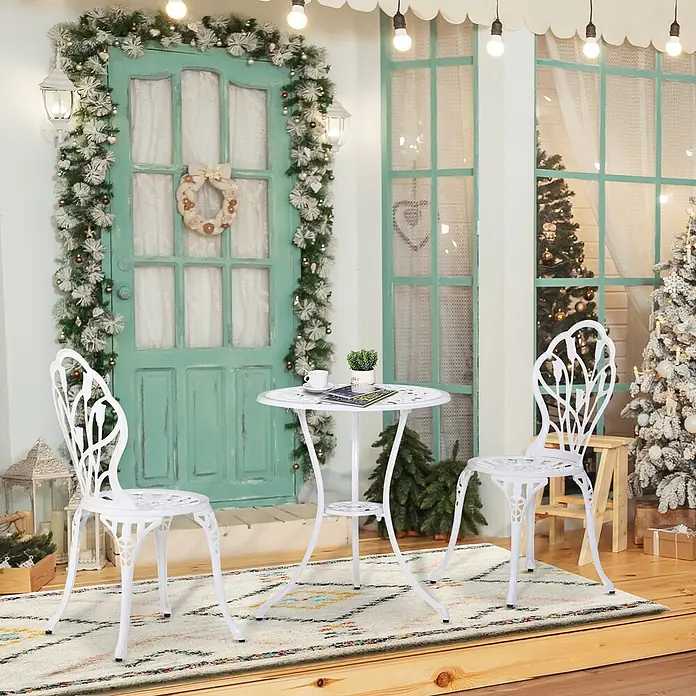 Outsunny Gartenstuhl-Set mit Schirmloch - 2 Stk., Aluminium, Weiß, B x T x H: 60 x 48 x 67 cm - Weißes Metall-Bistro-Set mit zwei verzierten Stühlen und einem runden Tisch auf einer weihnachtlich dekorierten Veranda.
