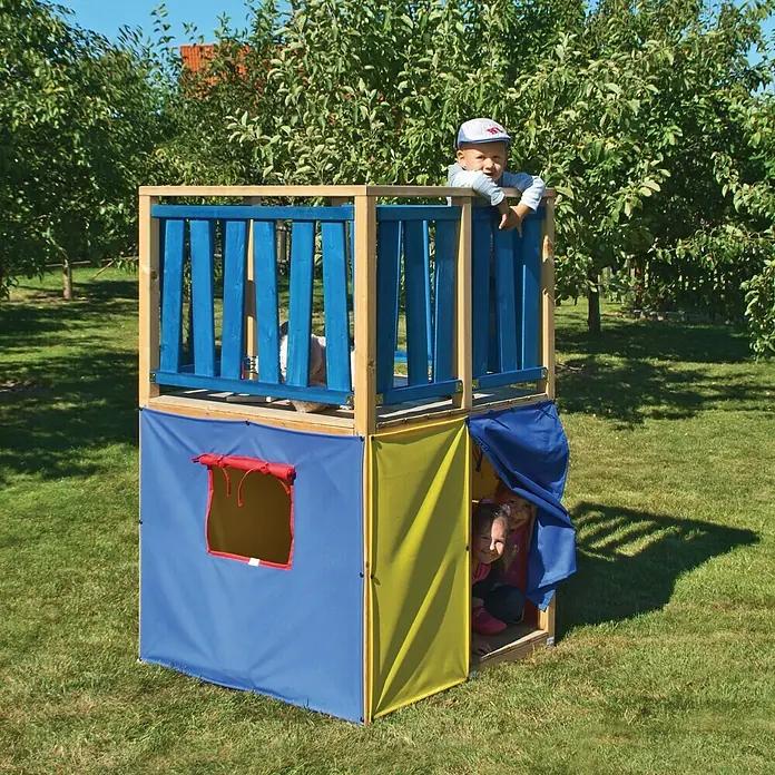 Kinderspielturm Funny - L x B x H: 140 x 100 x 160 cm - Ein zweistöckiges Spielhaus mit Kindern, wobei das obere Stockwerk blau und das untere mehrfarbig ist, steht im Garten.