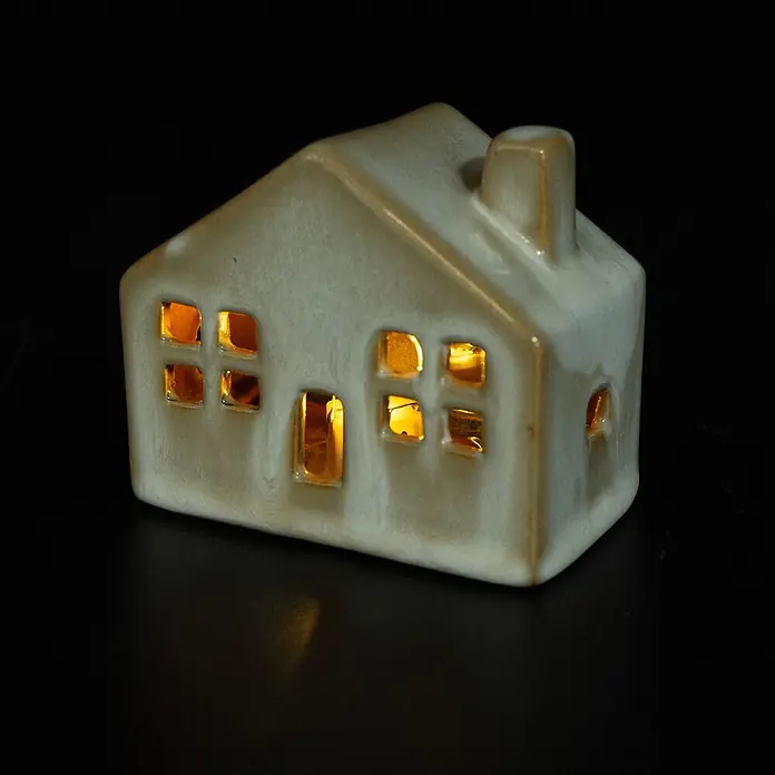 Dekoartikel LED Haus - 1 Stk., Sortiert, 8 x 4,5 x 7 cm - Cremefarbener Keramik-Teelichthalter in Hausform mit warmem Licht aus den Fenstern.