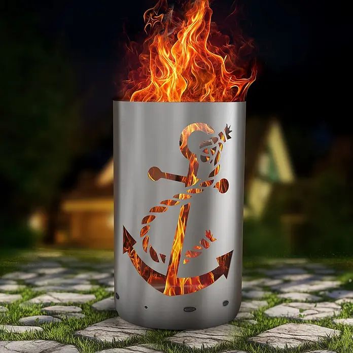 TiKo-Design Holzkohlegrill Feuertonne-Anker - Grau - Feuerkorb aus Edelstahl mit Anker-Ausschnitten, brennt hell in der Nacht auf einem Steinweg.
