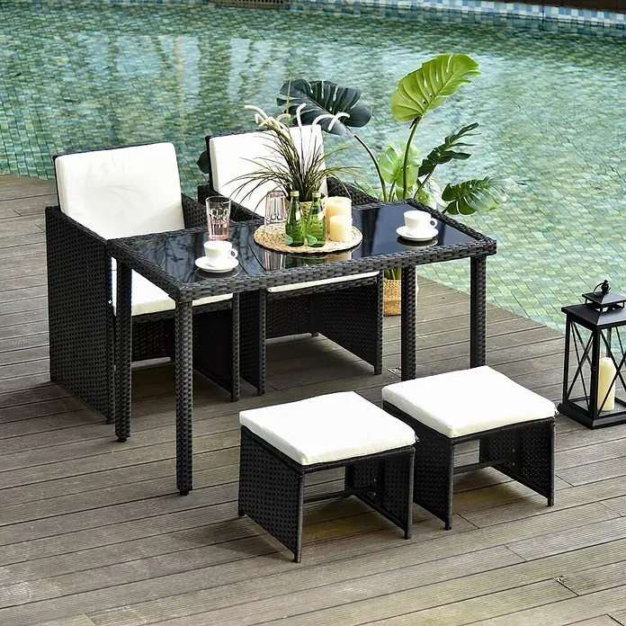 Outsunny Loungemöbel-Set - 5 -tlg., PE Polyrattan, Metall, Hartglas, Polyester, Schwarz, Beige - Schwarzes Rattan-Gartenessgruppe mit weißen Kissen, bestehend aus Tisch, zwei Stühlen und zwei Hockern, auf einer Holzterrasse am Pool.