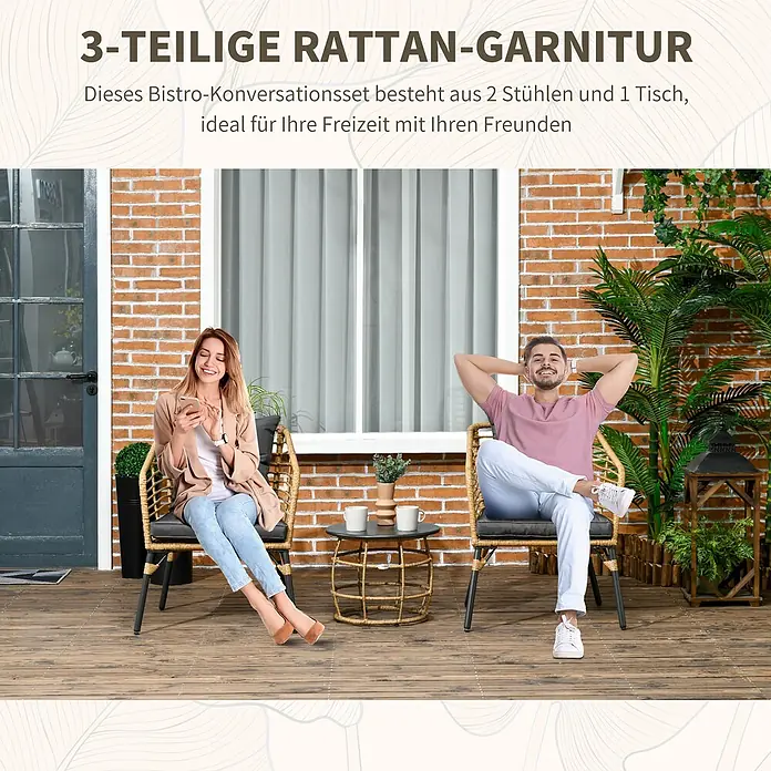 Outsunny Loungemöbel-Set mit Tisch - 3 -tlg., Stahl, Polyester, PE Rattan, Boho Design, Sand, Dunkelgrau - Ein 3-teiliges Rattan-Bistroset mit zwei Stühlen, dunklen Kissen und einem kleinen Tisch auf einer Terrasse, von zwei Personen genutzt.