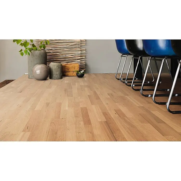 Living by Haro Parkett - Amerikanischer Kirschbaum, Schiffsboden, 2.200 x 180 x 13,5 mm - Heller Holzfußboden mit Naturmaserung in einem modernen Raum mit Dekoartikeln und Stühlen verlegt.
