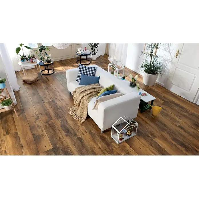 Living by Haro Laminat Gigante - Eiche Fattoria, Landhausdiele, 2.200 x 243 x 8 mm - Braune Holzfußbodenbretter in einem gemütlichen Wohnzimmer, die eine reiche Maserung zeigen.