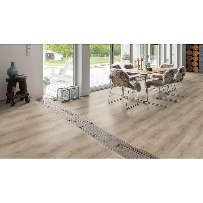 Living by Haro Laminat Gigante - Eiche Laval Grau, Landhausdiele, 2.200 x 243 x 8 mm - Helles Laminatboden in Holzoptik mit dunklem, rustikalem Holzbalken als Akzent, in modernem Wohnraum.