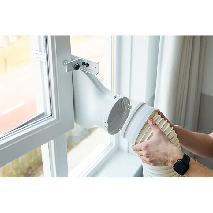 Eurom Adapter Window Way Out - Passend für: Klimageräte bis 18000 BTU - Hände verbinden einen weißen flexiblen Abluftschlauch mit einem weißen Kunststoff-Fensterdichtungsset am Fensterrahmen.
