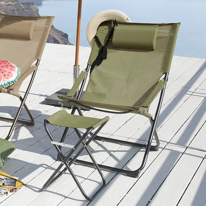 SVITA Garten-Liegestuhl TOMRA mit Hocker - 1 Stk., 50 % Kunststoffgewebe, 50 % Stahl, Klappbar, Grün, B x T x H: 61 x 77 x 93 cm - Olivgrüner Klappliegestuhl mit Kopfstütze und passender Fußstütze auf einer Terrasse am Meer.