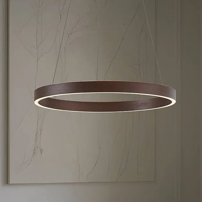 Lucande Pendelleuchte Yonam - braun / rost, kaffeebraun, weiß - Große, dunkelbraune kreisförmige Pendelleuchte mit beleuchteter Innenkante, hängt in einem modernen Interieur.