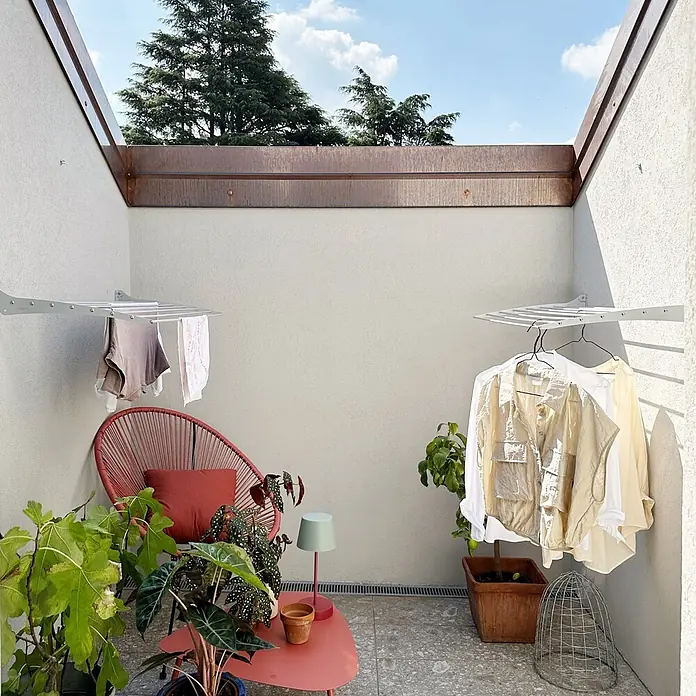 Foxydry Wandwäschetrockner Fold 100 Weiß - 102 cm, Farbe: Weiß - Zwei silberne, wandmontierte Wäschetrockner mit Kleidung an einer Terrassenwand.