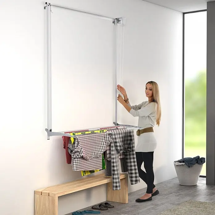 Foxydry Wandwäschetrockner Wall 80 Grau - 88 cm, Farbe: Stahlgrau - Silberner Wandwäschetrockner mit Rollenzugsystem, in Gebrauch mit aufgehängter Kleidung.