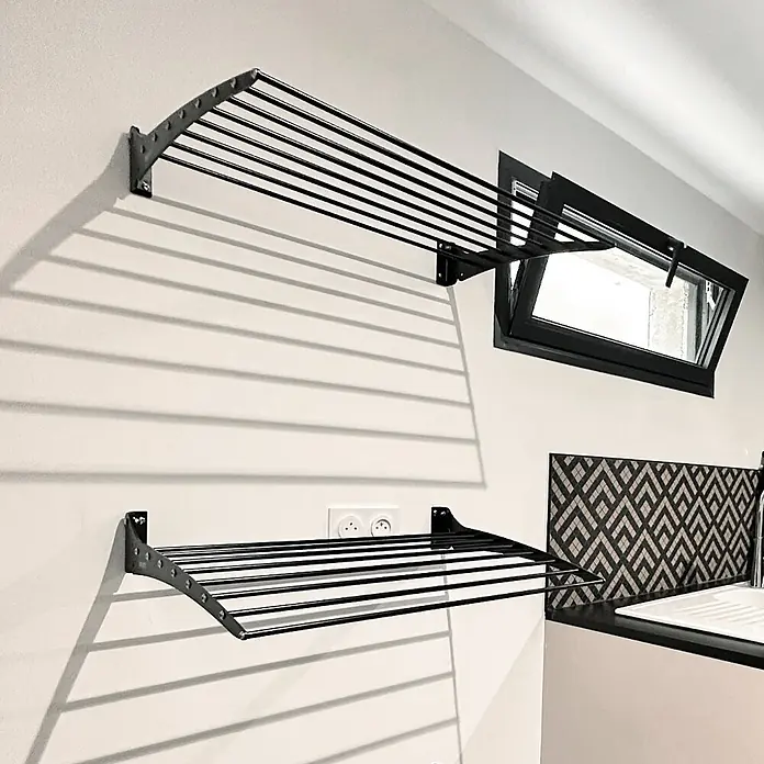 Foxydry Wandwäschetrockner Down 80 Schwarz - 82 cm, Farbe: Schwarz - Schwarzes, wandmontiertes Metall-Wäschegestell mit parallelen Stäben, in einem Hauswirtschaftsraum installiert.