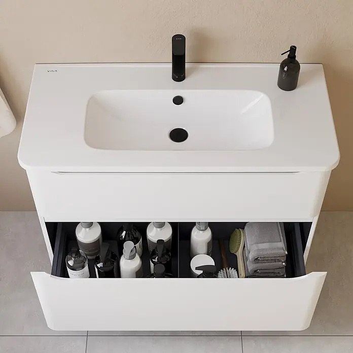 VitrA Integra Round Badmöbel-Set - Gesamtbreite Badmöbel: 100 cm, Weiß, Matt - Weißer VitrA Badunterschrank mit integriertem Waschbecken und schwarzer Armatur, Schublade offen mit Badartikeln und Handtüchern.