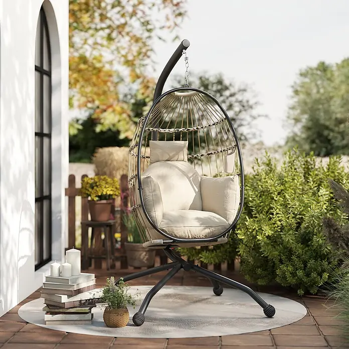 Outsunny Hängesessel - L x B x H: 120 x 88 x 192 cm, Khaki - Schwarzer Eierstuhl mit beigen Kissen auf einer Terrasse für Entspannung im Freien.