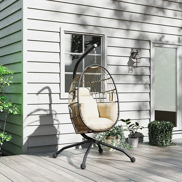Outsunny Hängesessel - L x B x H: 120 x 88 x 192 cm, Khaki - Ein eiförmiger Hängesessel mit schwarzem Metallgestell, Naturgeflecht und cremefarbenen Kissen steht auf einer Holzterrasse.