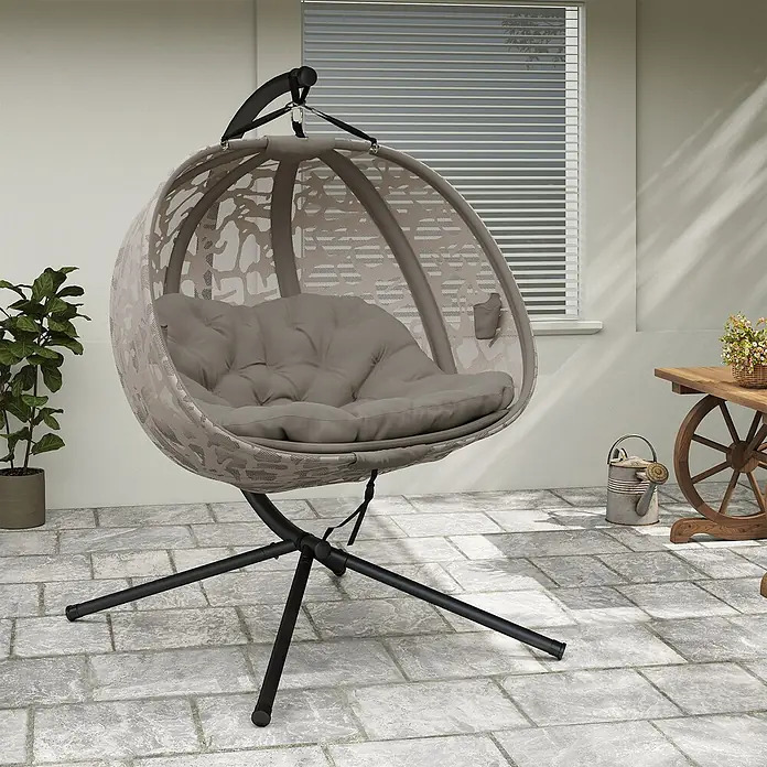 Outsunny Hängesessel - Sand - Beiger Hänge-Eierstuhl aus Rattan mit dunkelgrauem Gestell und taupefarbenem Kissen auf einer Terrasse.