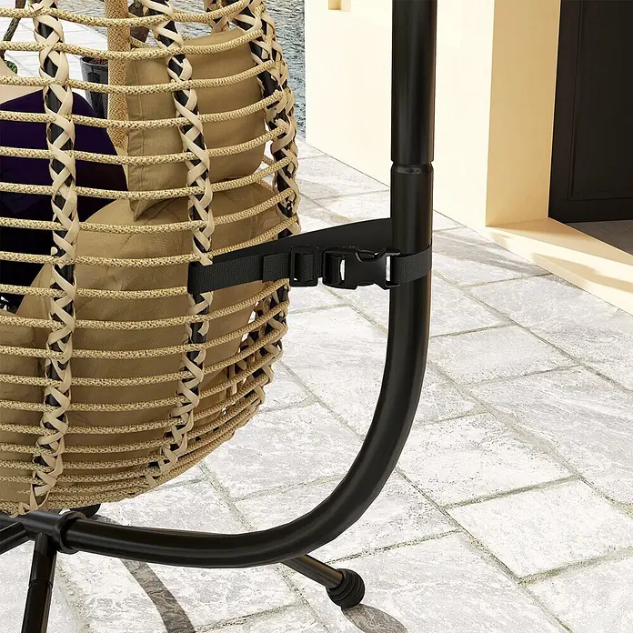 Outsunny Hängesessel - L x B x H: 110 x 100 x 188 cm, Beige - Nahaufnahme eines beigen geflochtenen Hängesessels mit Kissen, mit schwarzem Gurt an schwarzem Metallständer befestigt, auf gefliestem Patio.