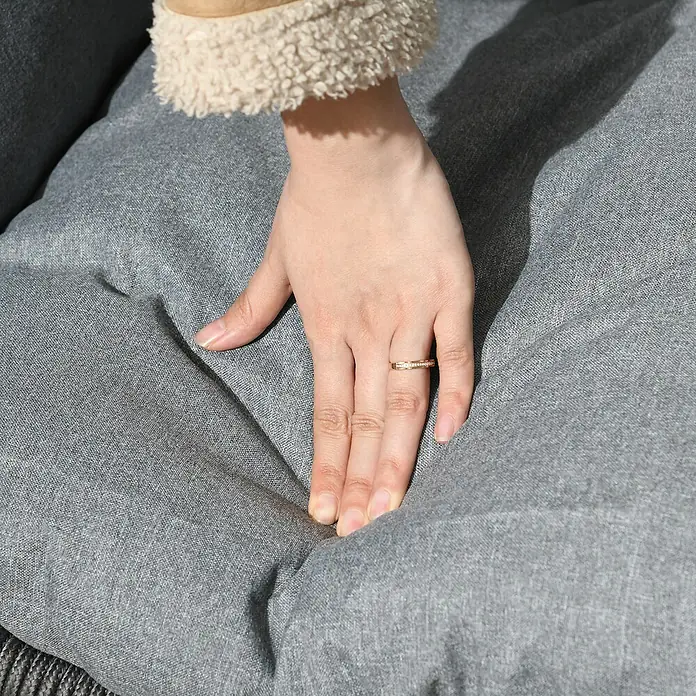 Outsunny Hängesessel - Grau - Eine Hand mit Ring drückt in ein weiches, graues Polsterkissen und demonstriert dessen plüschige Textur.