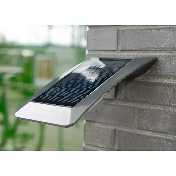 Lutec Aplique solar para exterior Zerta - 3 W, L x An x Al: 25,5 x 20 x 14,5 cm, Gris, IP44 - Primer plano de una elegante lámpara solar montada en una pared, que combina iluminación ecológica y diseño moderno.