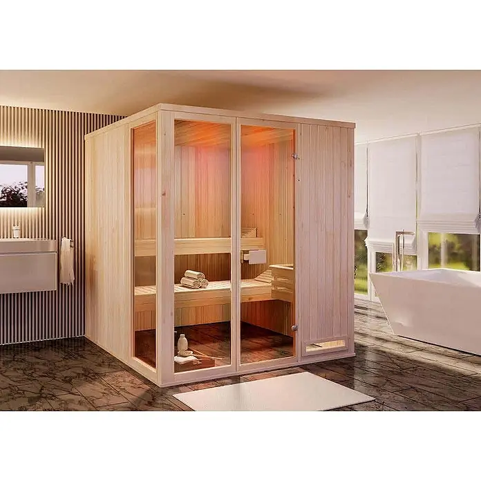 FinnTherm Massivholzsauna Oda - L x B x H: 194 x 194 x 199 cm - Helle Holzsaunakabine mit Glastüren und Innenbänken, in einem modernen Badezimmer mit Badewanne.