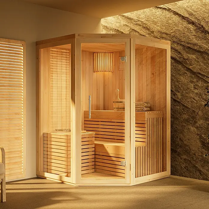 FinnTherm Massivholzsauna Ylva - L x B x H: 141 x 141 x 213 cm - Eckige Sauna aus hellem Holz mit Glastür, gebrauchsfertig in einem Raum mit Felswand dargestellt.