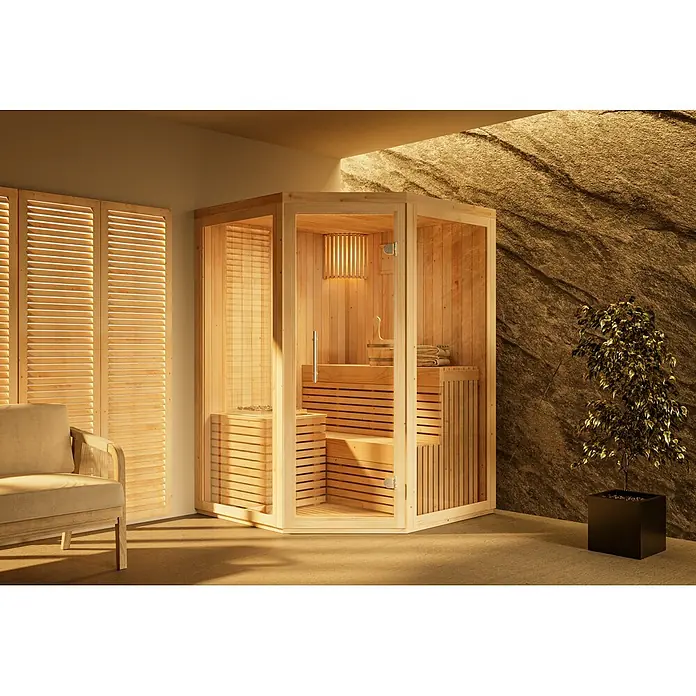 FinnTherm Massivholzsauna Ylva - L x B x H: 141 x 141 x 213 cm - Helle Holz-Ecksauna mit Glaspaneelen, Sitzgelegenheiten, Ofen und Zubehör in einem Innenraum.