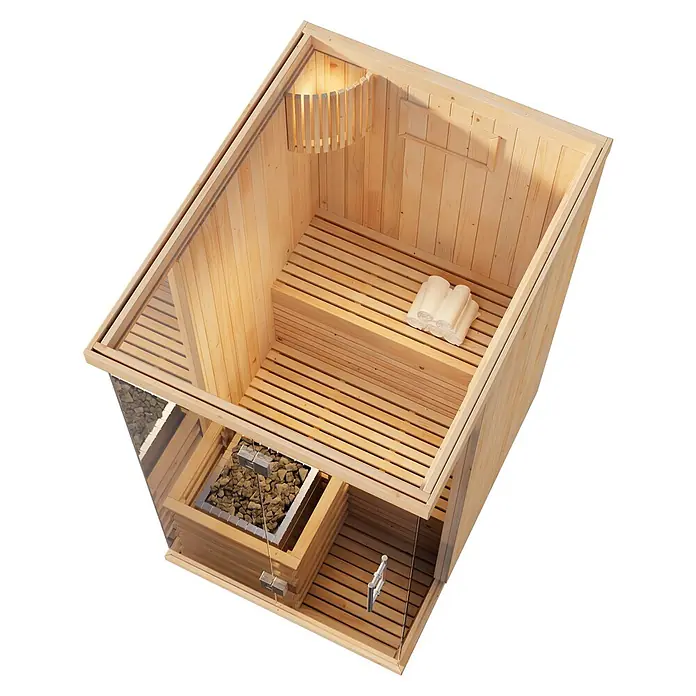 FinnTherm Massivholzsauna Milla -  - Sauna-Innenansicht aus hellem Holz und Glas mit Bänken, Steinofen, Leuchte und gefalteten Handtüchern.